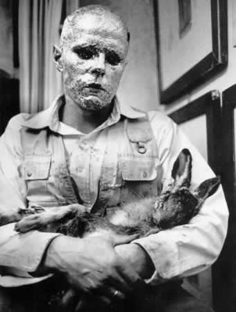 Fotografija št. 6. Joseph Beuys: How to Explain Pictures to a Dead Hare, Galerie Schmela, Düsseldorf, 26. november 1965.<sup class="modern-footnotes-footnote modern-footnotes-footnote--expands-on-desktop " data-mfn="2" data-mfn-post-scope="0000000000000c170000000000000000_3385"><a href="javascript:void(0)" role="button" aria-pressed="false" aria-describedby="mfn-content-0000000000000c170000000000000000_3385-2">2</a></sup><span id="mfn-content-0000000000000c170000000000000000_3385-2" role="tooltip" class="modern-footnotes-footnote__note" tabindex="0" data-mfn="2">Fotografija s spletne strani https://www.wikiart.org/en/joseph-beuys/how-to-explain-pictures-to-a-dead-hare-1965-1. Ostale fotografije so nam posredovale_i umetnice_ki.</span> Umetnik zaščitniško ziblje mrtvega zajca podobno kot Kristusova mati svojega sina v upodobitvah pietà (glej Antliff, 2014: 62–63). (…) »Fotografija tega performansa, ki so jo nekateri kritiki označili za Mona Lizo 20. stoletja, je zelo vplivna, priljubljena in vseprisotna.« (Čekada, povzeto po Šimunović, 2016: 69).